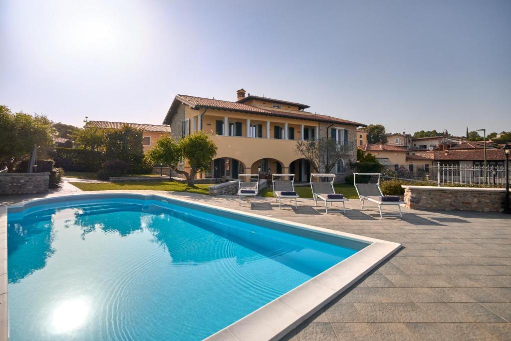 a swimming pool in front of a house at Villa Ardea in Soiano del Lago