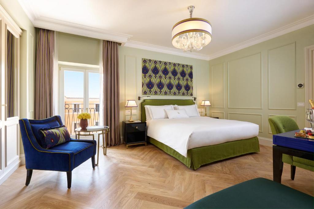 a bedroom with a bed and a blue chair at Palazzo Ripetta in Rome