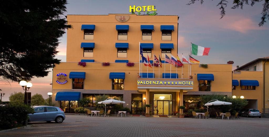 un hôtel avec drapeaux devant un bâtiment dans l'établissement Valdenza Hotel, à Campegine