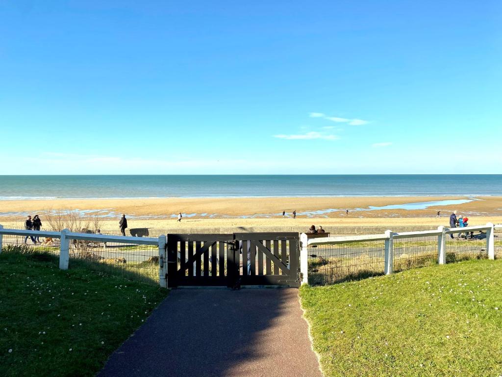 - une passerelle menant à la plage avec des personnes se promenant sur la plage dans l'établissement Cabourg-la plage à vos pieds, à Cabourg