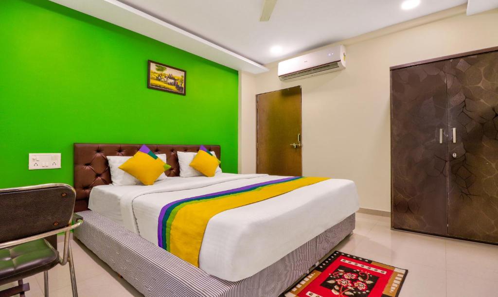 Un dormitorio con una pared verde y una cama en Itsy By Treebo - Carnival Inn, en Nagpur
