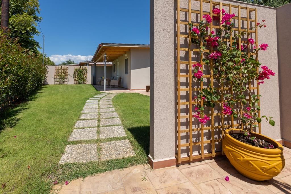 a garden with a fence with flowers in a yellow pot at Messinian Monte e Mare in Kalamata