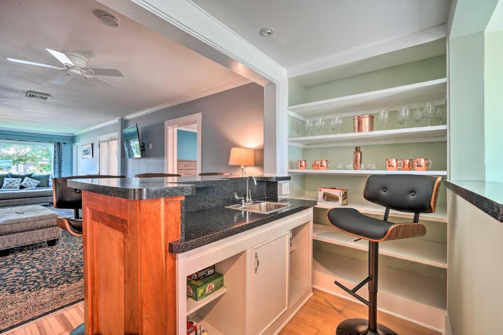 a kitchen with a counter with a sink and a chair at Downtown Retreat with Grill, Fire Pit and Wet Bar in Lake George