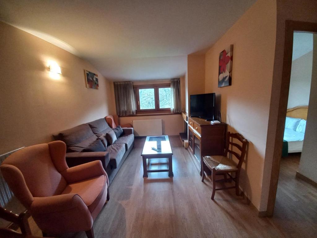 ein Wohnzimmer mit Sofa und Tisch in der Unterkunft La Pleta de Soldeu-Vacances Pirinenca in Soldeu