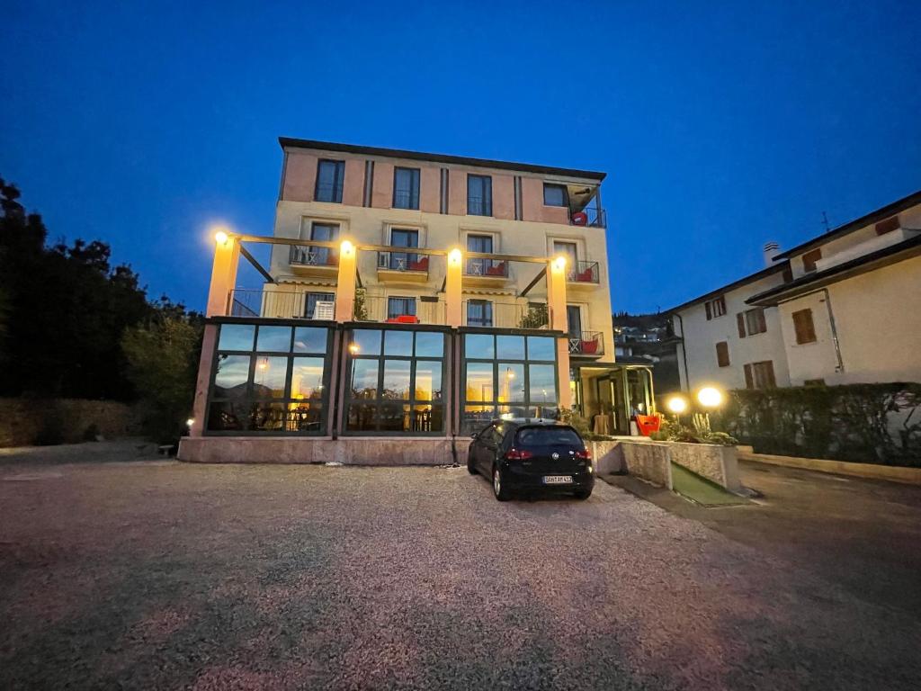 un coche aparcado delante de un edificio por la noche en Hotel Al Castello, en Torri del Benaco