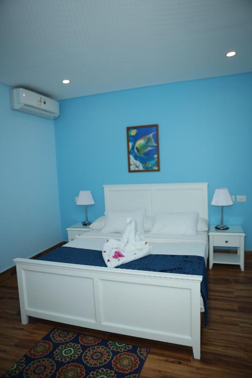 a bedroom with a white bed with a blue ceiling at Tiba Rose hurghada in Hurghada
