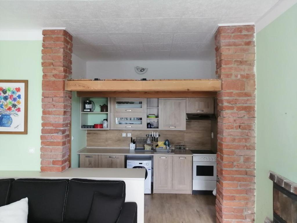 an open kitchen with a brick wall and a table at Apartmán Šumperk in Šumperk