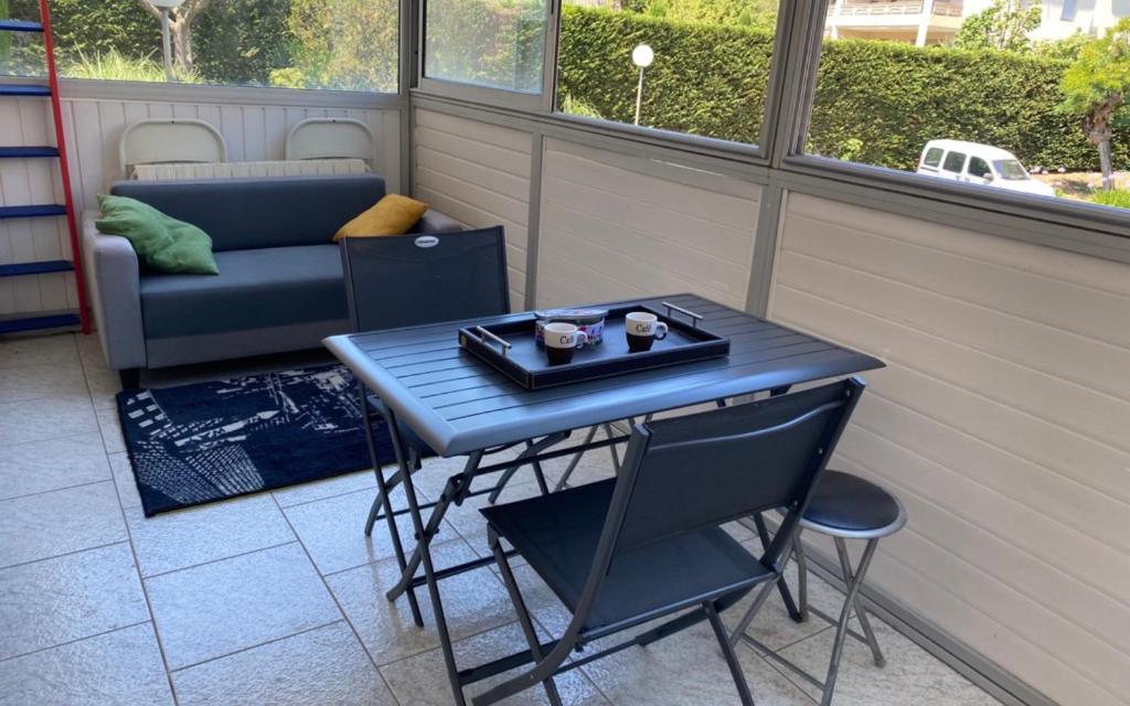 einen blauen Tisch und Stuhl in einem Zimmer mit einem Sofa in der Unterkunft Apt familial quartier Fontonne à Antibes by Weekome in Antibes