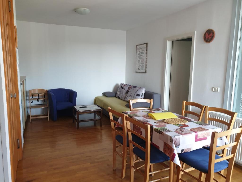 ein Wohnzimmer mit einem Tisch, Stühlen und einem Sofa in der Unterkunft Apartment Laguna 70 in Izola