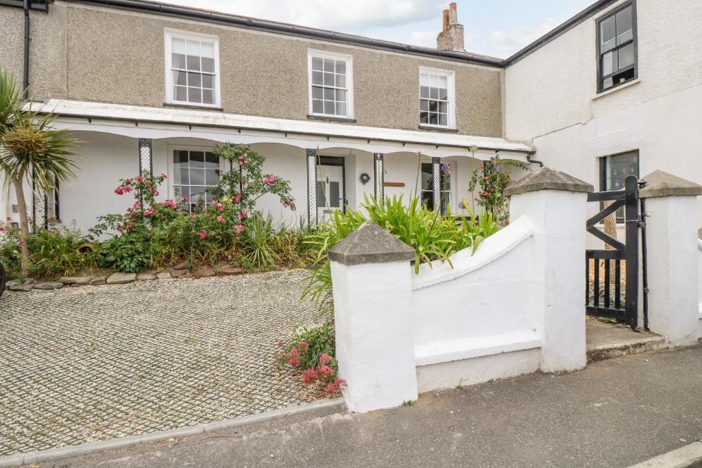 a white fence in front of a house at 1 Dormer Villas in Porthscatho