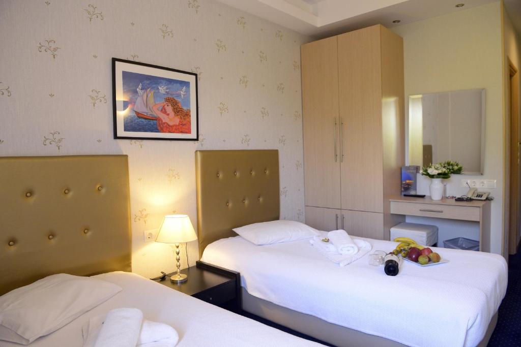 um quarto de hotel com duas camas e um espelho em Phidias Hotel by Oniro em Atenas