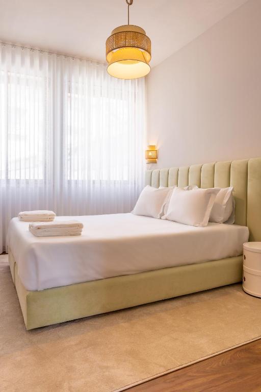 a bedroom with a large bed with white pillows at ORM- Flores Apartment in Porto