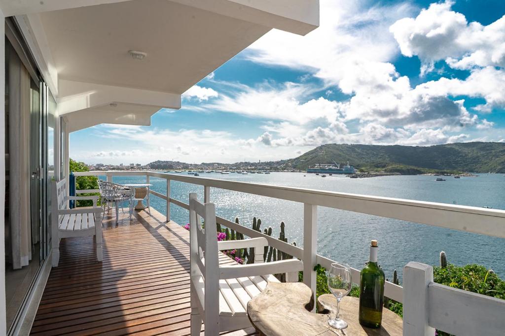 a balcony of a house with a view of the water at Loft Grécia In in Arraial do Cabo