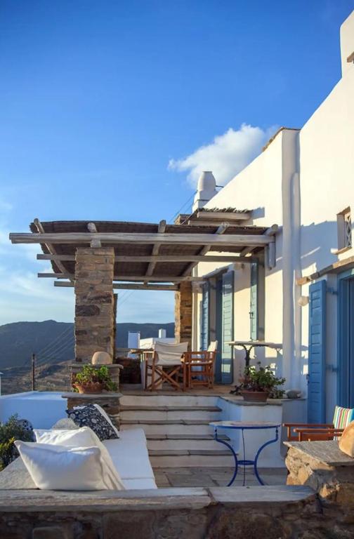 a patio with a table and chairs on a house at Elegant island house in Khatzirádhos
