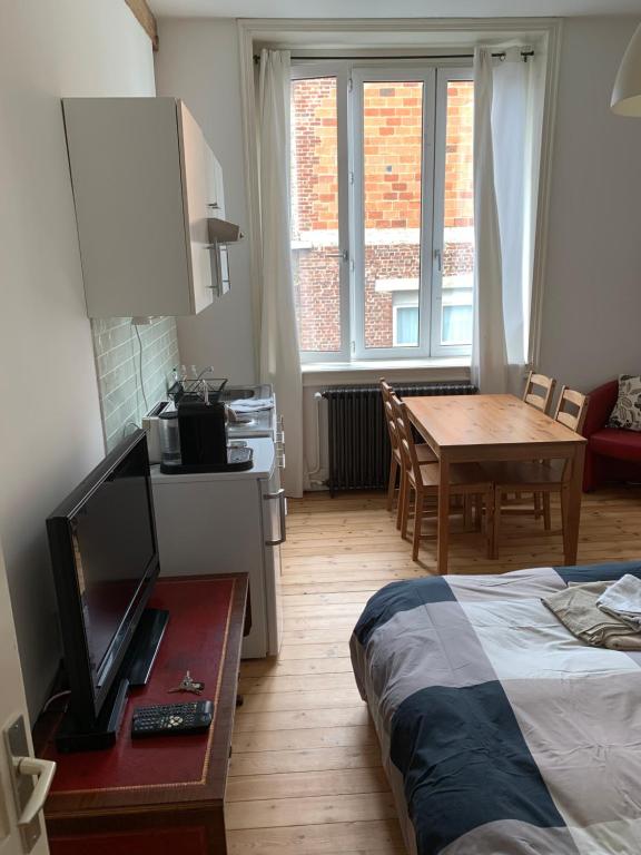 a bedroom with a bed and a table and a dining room at VIEUX LILLE Porte de Gand Bienvenue chez NESTYOU, Lille in Lille