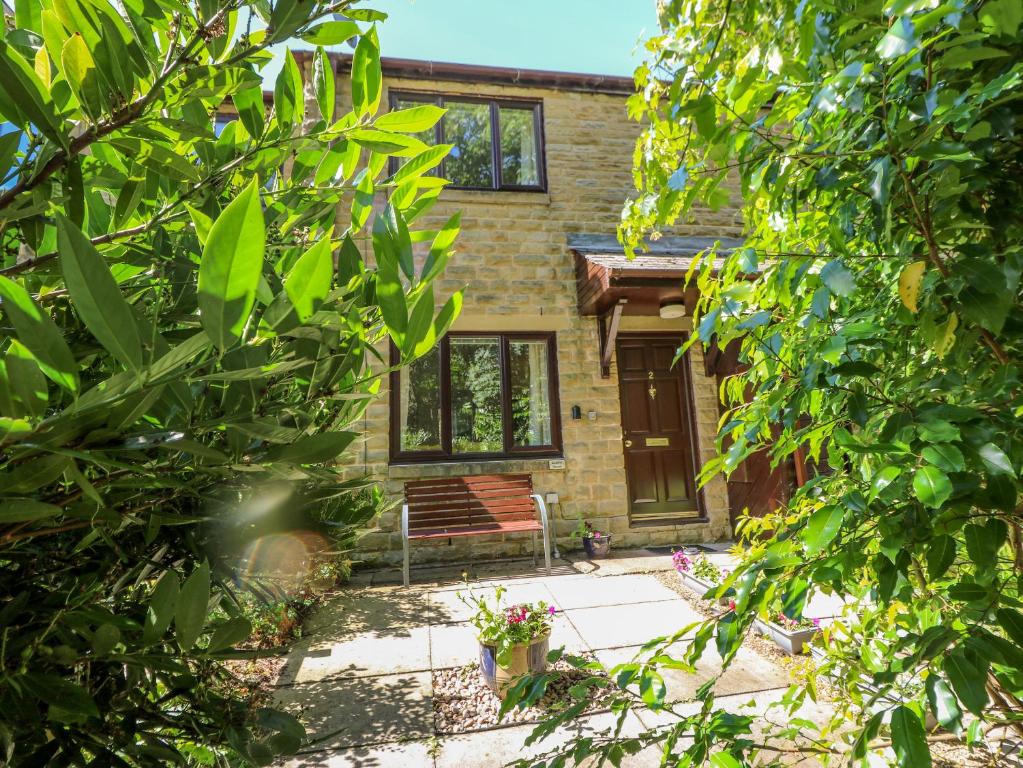 a brick house with a bench in front of it at Avaelie House in Hebden Bridge