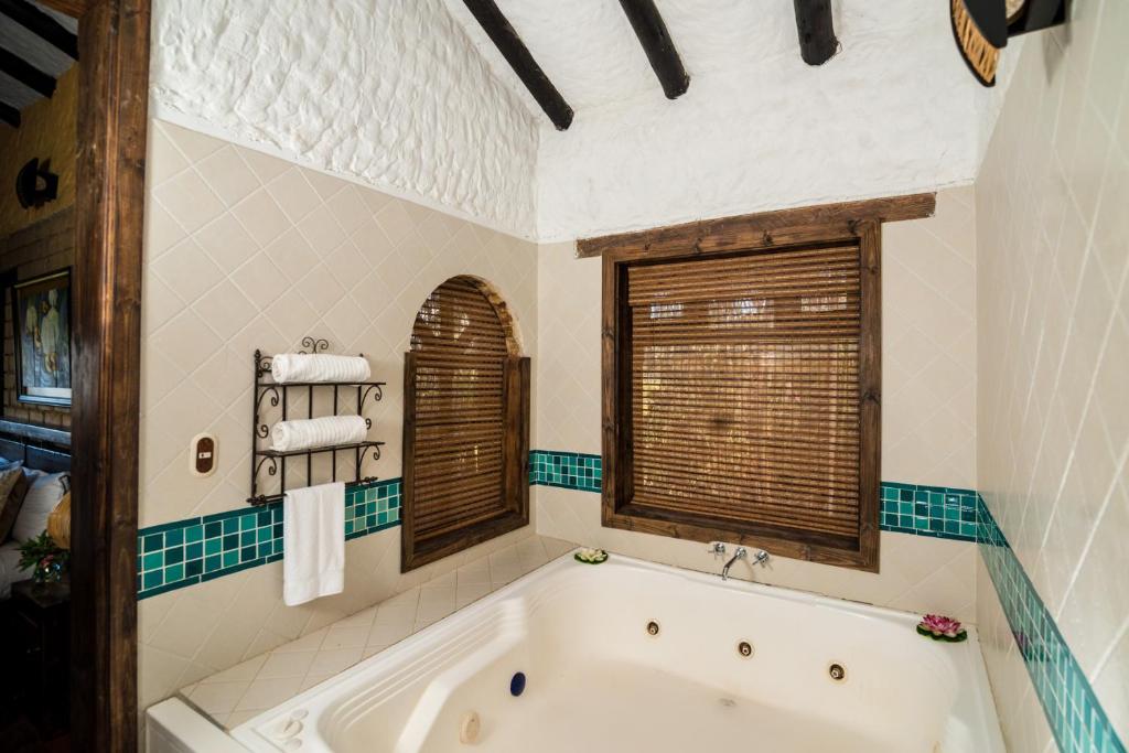 a bath tub in a bathroom with a window at Hotel Boutique Guatika in Tibasosa