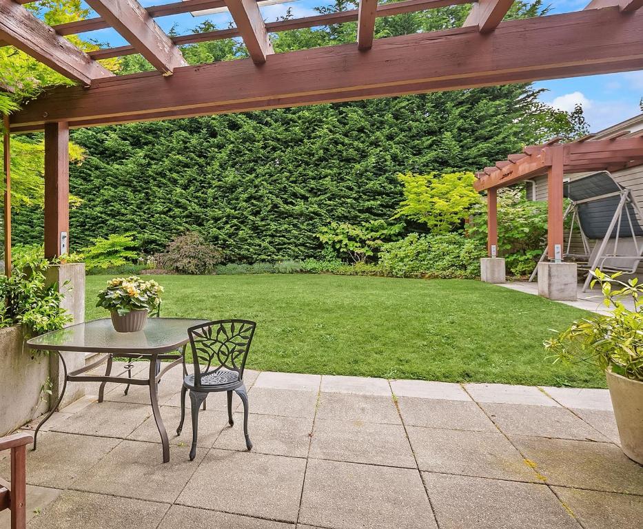 d'une terrasse avec une table, une chaise et une pelouse. dans l'établissement Ravenna Retreat - Free Parking - 1GBPS Fiber WIFI - Near UW, à Seattle