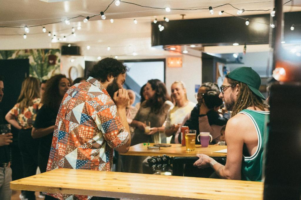 un grupo de personas de pie alrededor de un bar en Auberge Saintlo Montréal Hostel, en Montreal