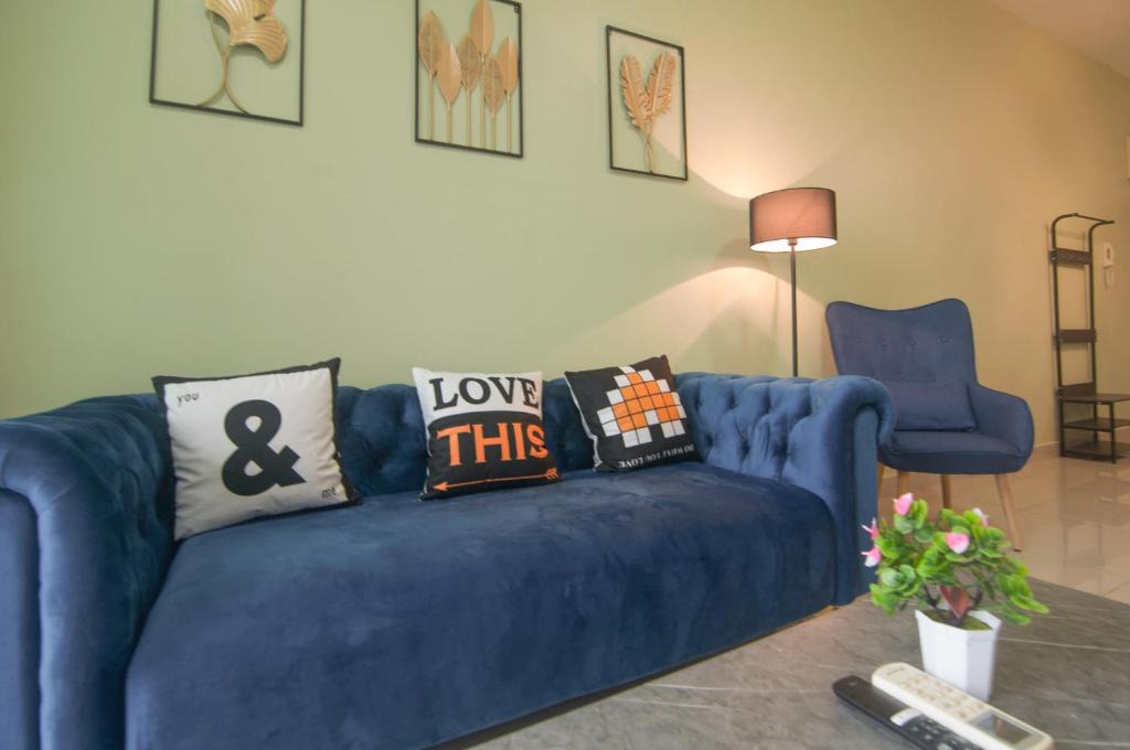 a blue couch with pillows on it in a living room at Mutiara Ville Cyberjaya by Idealhub in Cyberjaya