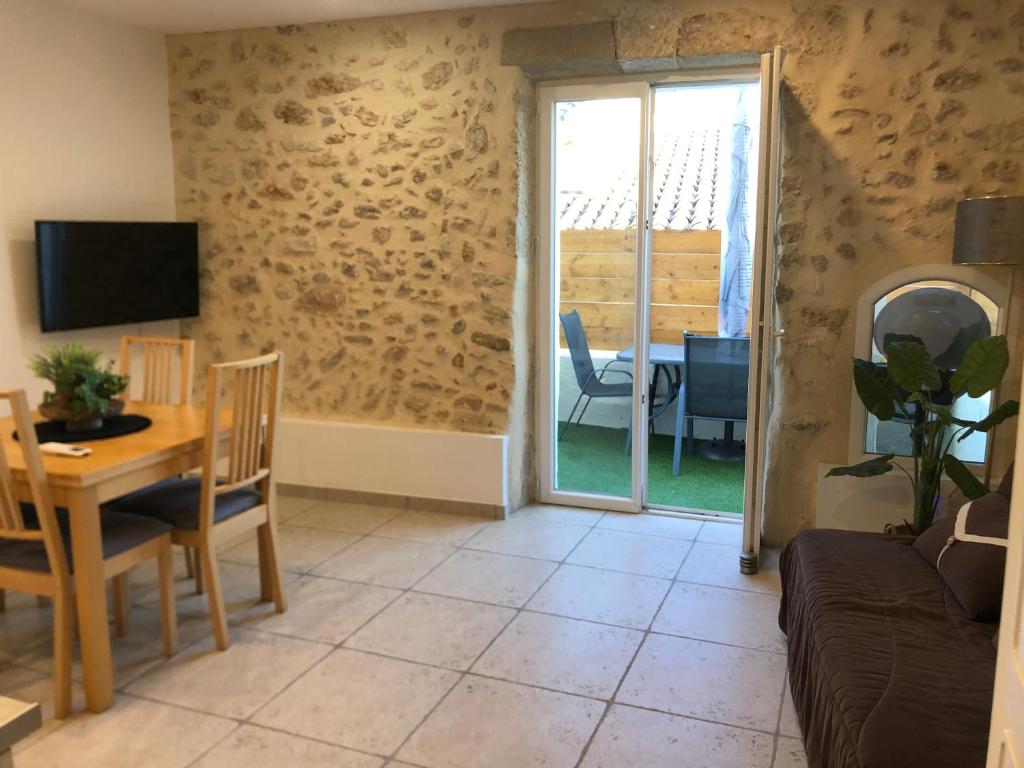 ein Wohnzimmer mit Tisch und Couch und ein Esszimmer in der Unterkunft Entre mer, rivière et montagne f2 avec terrasse :) in Pailhès