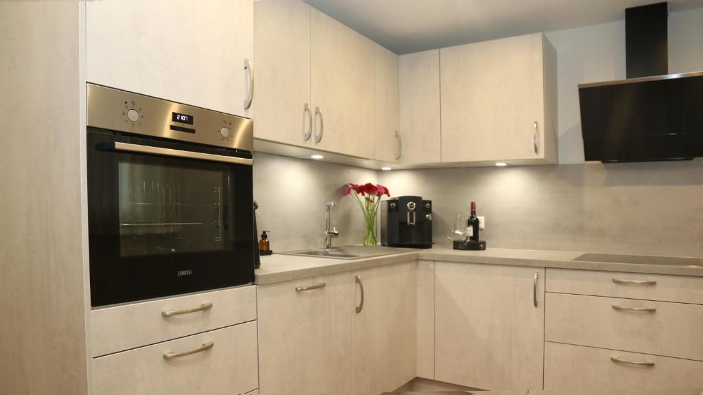 a kitchen with white cabinets and a black appliance at Apartment Tomm by Europa-Park & Rulantica in Rust