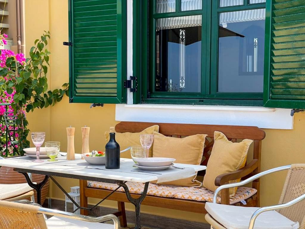 stół i krzesła na tarasie z zielonym oknem w obiekcie Casa di Pupa w mieście Minia