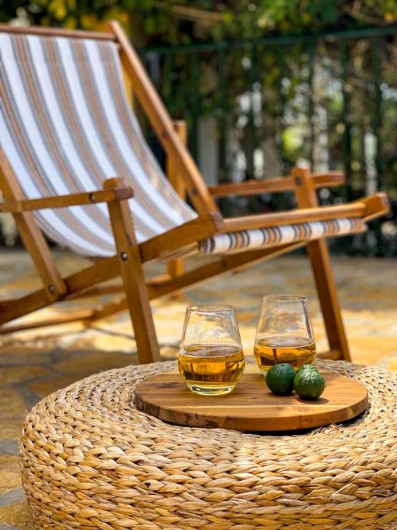 dwa kieliszki whisky na drewnianej tacy obok krzesła w obiekcie Casa di Pupa w mieście Minia