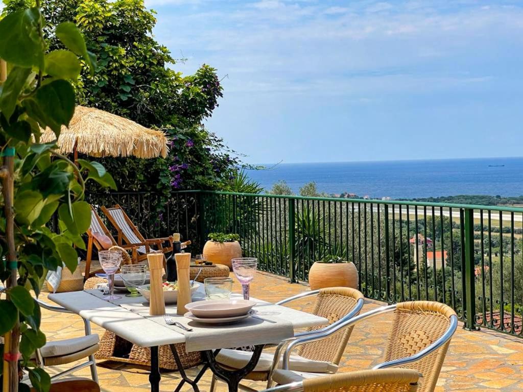 una mesa y sillas en un balcón con vistas al océano en Casa di Pupa, en Minia