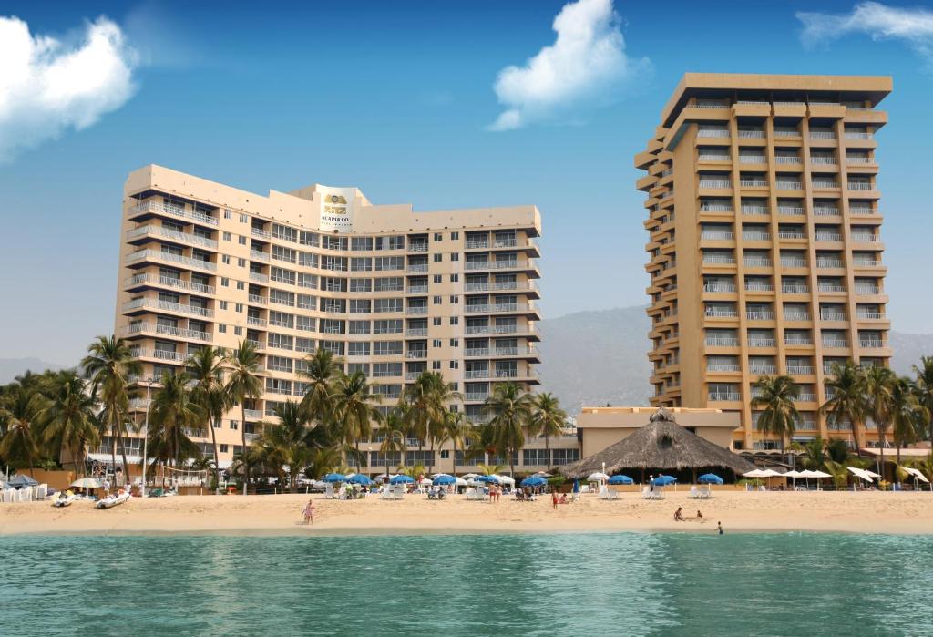 een strand met twee hoge gebouwen en een hotel bij Ritz Acapulco All Inclusive in Acapulco