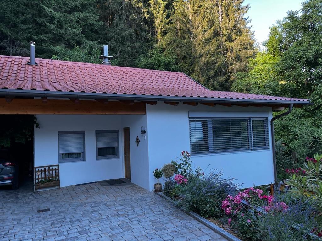 Casa blanca con techo rojo y entrada en Ferienwohnung Beate Hassler, en Berg im Drautal