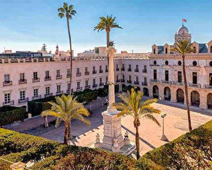 un edificio con una estatua frente a un edificio con palmeras en Expoholidays - Plaza Vieja con PARKING gratis, en Almería