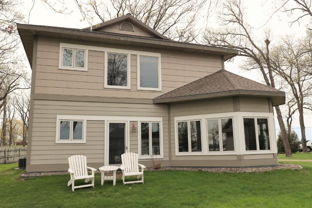 two chairs and a table in front of a house at Bay Colony 775 in Nisswa