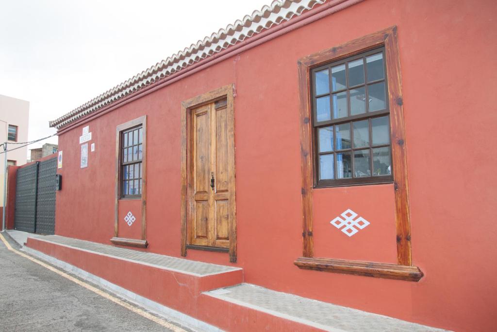 a red building with two windows and a door at Villa Perestelo in Los Sauces