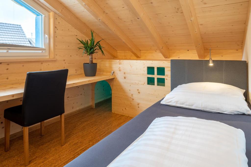a bedroom with a bed and a desk and a chair at Alb Chalet in Meßstetten