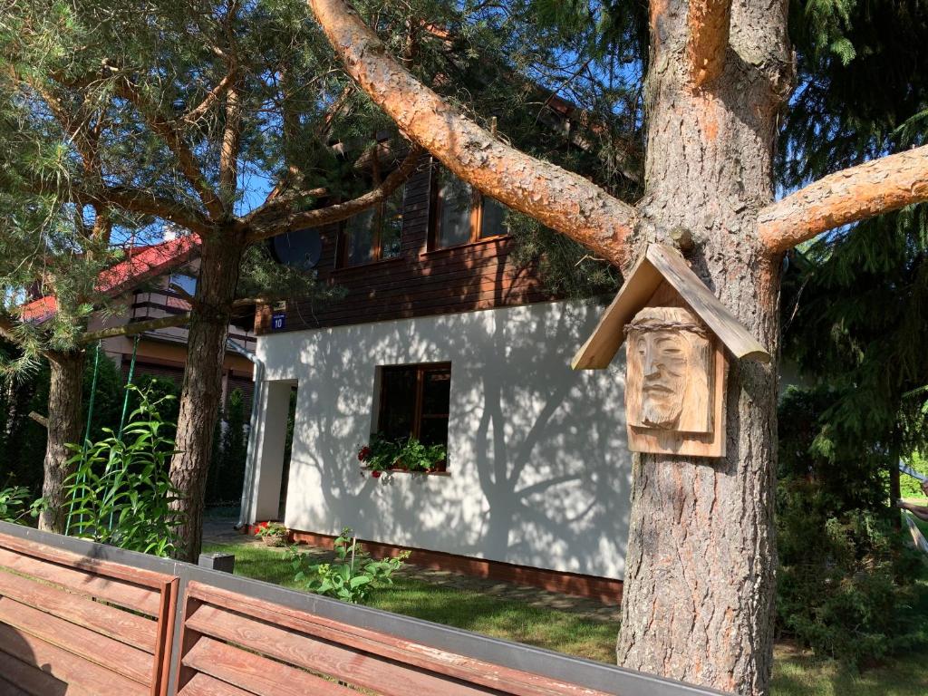 una croce di legno su un albero di fronte a una casa di Dom nad jeziorem Tajty a Giżycko