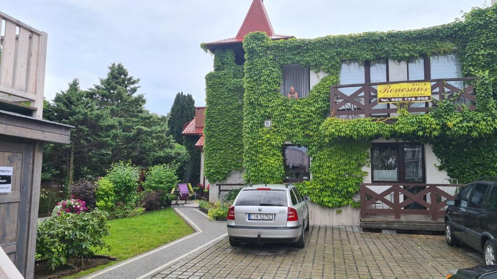 samochód zaparkowany przed domem z bluszczem w obiekcie RENESANS we Władysławowie