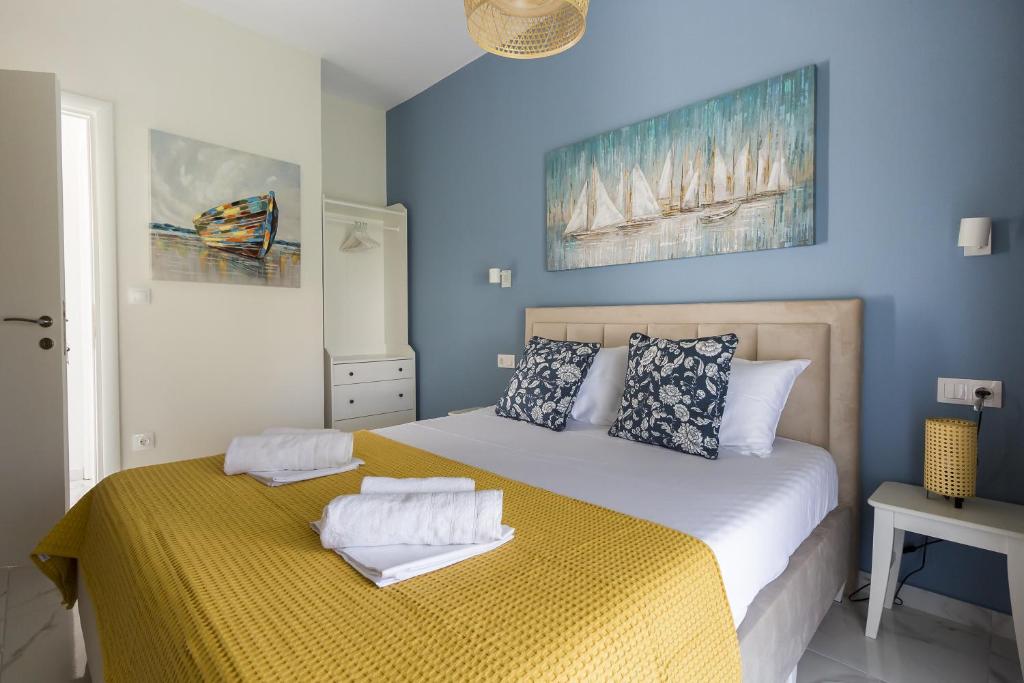 Un dormitorio azul con una cama con toallas. en Maya apartments Hanioti en Hanioti
