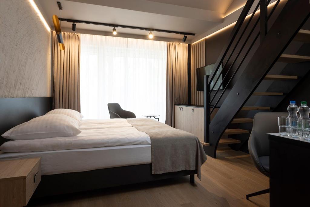 a bedroom with a large bed and a staircase at Four Winds in Krynica Morska