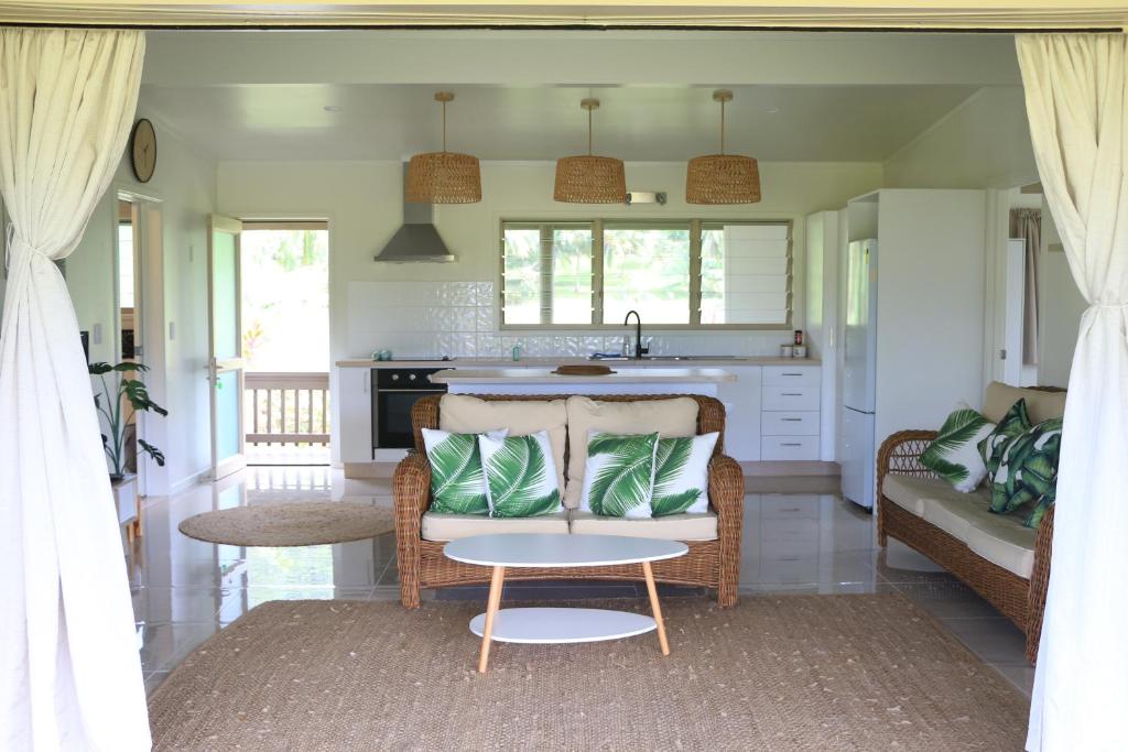 a living room with a couch and a kitchen at Serene Holiday Home in Rarotonga