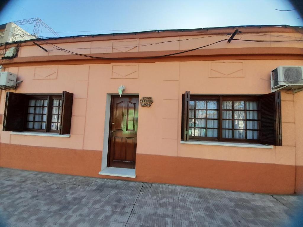 ein Haus mit zwei Fenstern und einer Tür in der Unterkunft Casa una habitación in Colonia del Sacramento