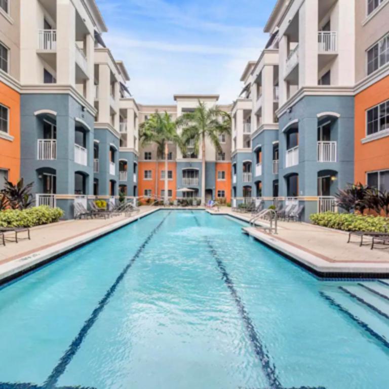 a swimming pool with blue water in front of buildings at Beautiful Apartment with Pool in Miami in Miami