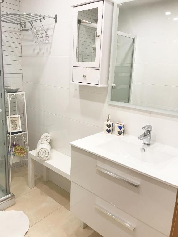 biała łazienka z umywalką i lustrem w obiekcie Benal Beach deluxe apartment with panoramic sea views w mieście Benalmádena