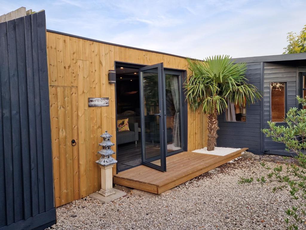 a shipping container house with a wooden deck at Birdsong lodge - peaceful - dog friendly in Sutton on Sea