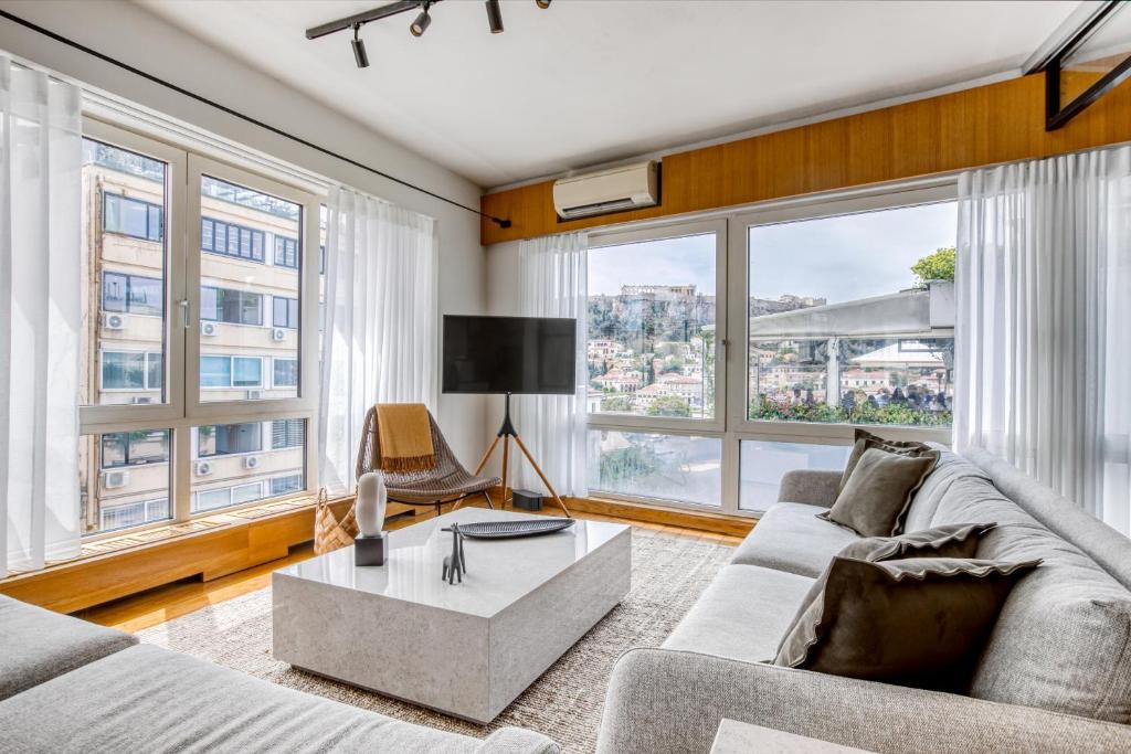 een woonkamer met een bank en een tafel bij Sunny Luxury Loft,Stunning Acropolis View, Jacuzzi in Athene