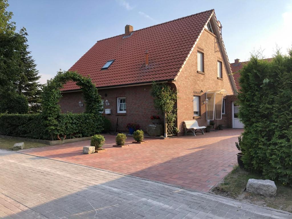 uma casa com uma entrada de tijolos em frente em Greetje Oog em Krummhörn