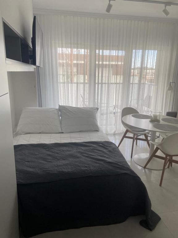 1 dormitorio con 1 cama, mesa y sillas en WhiteWave Apartament Pogorzelica en Pogorzelica