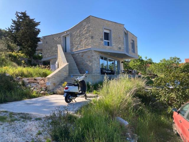 a scooter parked in front of a house at Seaview apartment in modern villa in Veli Iž