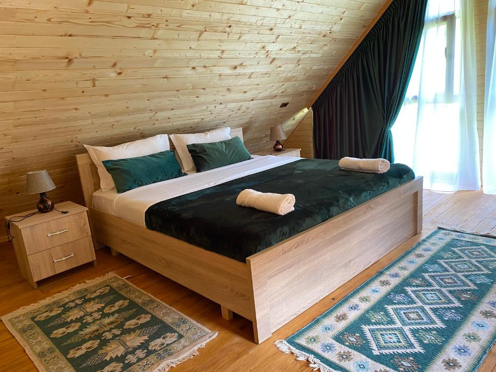 a bedroom with a large bed with two pillows on it at Guesthouse Demushi in Valbonë