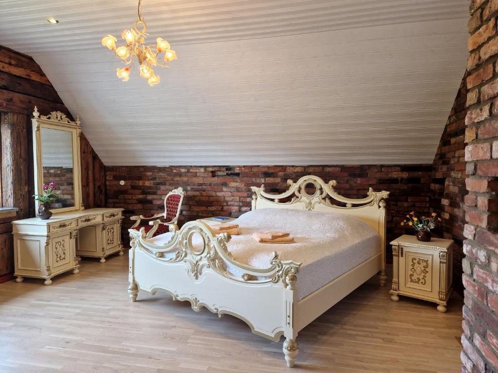 een slaapkamer met een wit bed en een bakstenen muur bij Uue-Jaani Talu puhkemaja in Ikla
